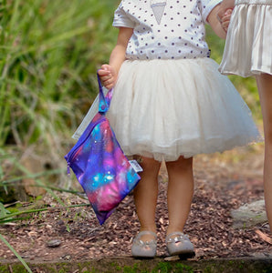 galaxy water resistant bag being held by girl in tutu dress